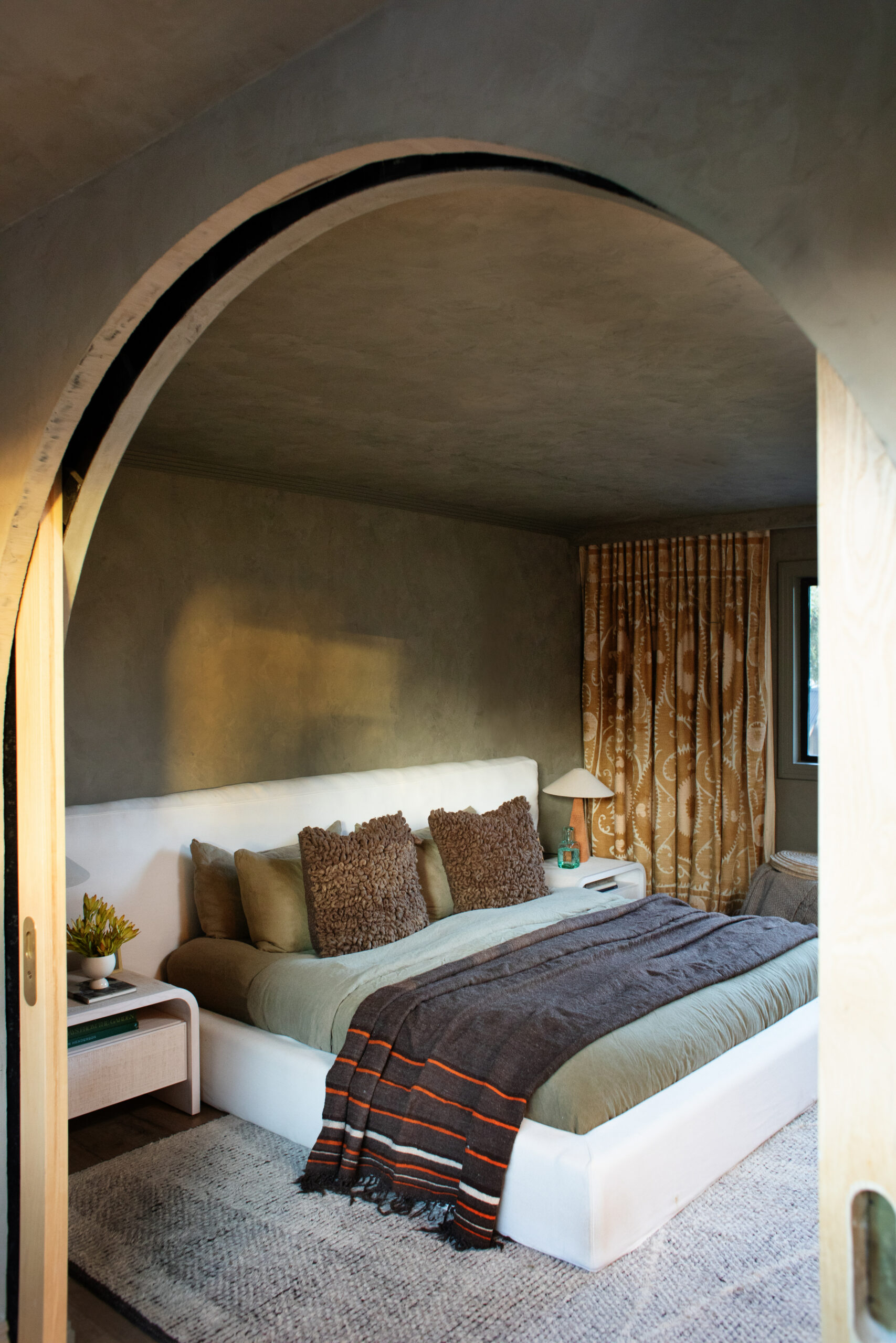 The apartment’s single bedroom, with textiles they’ve collected on their travels. (Eileen Roche/For Sonoma Magazine)