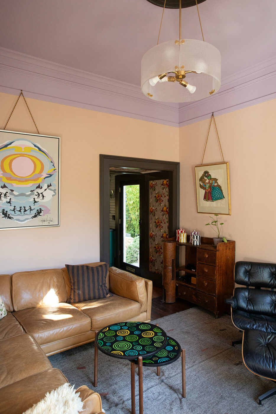Noah and Corey’s casual front living room, with whimsical artwork by Danish designer Bjørn Wiinblad. (Eileen Roche)