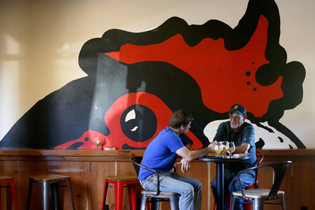 Will Poole, right, and his son Russ Poole enjoy some craft brews at HenHouse Brewing Company's tasting room in Santa Rosa. (Alvin Jornada / The Press Democrat)