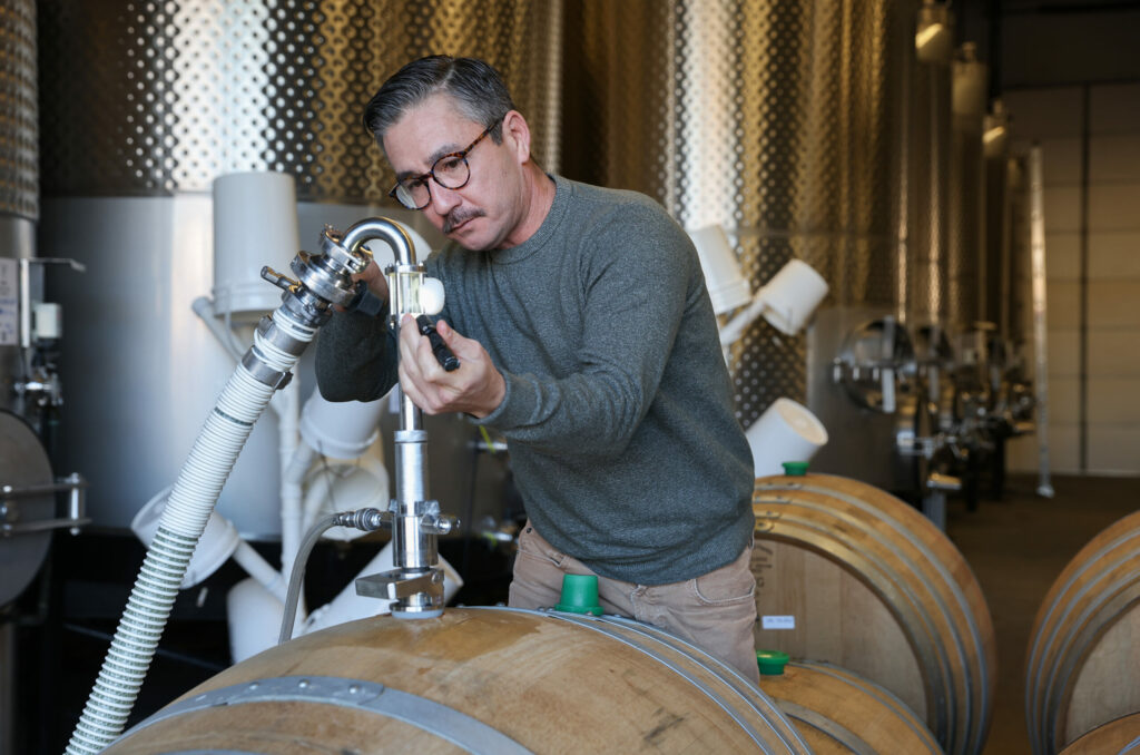 Director of winemaking Rob Fischer racks Picpoul wine from a puncheon to a tank at Marine Layer Wines in Healdsburg on Wednesday, January 8, 2025. (Christopher Chung/The Press Democrat)