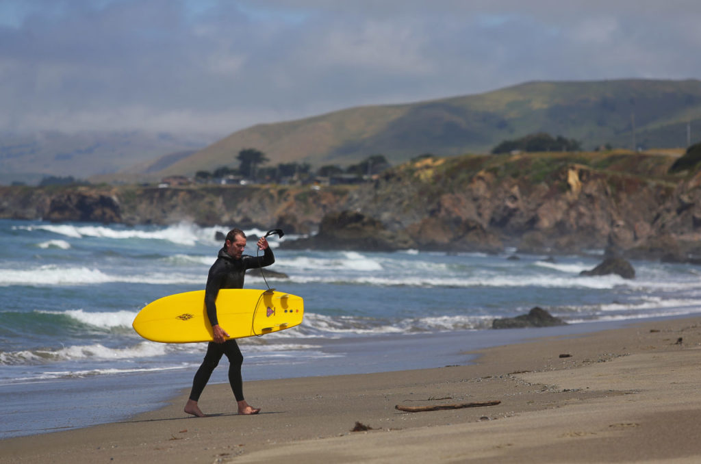 Bill Blaze, of Sebastopol, walks up the beach after surfing at Salmon Creek Beach, north of Bodega Bay. (Christopher Chung)