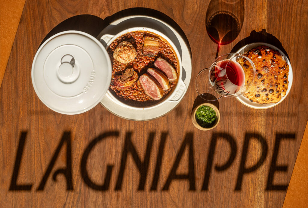 The shadow from a sign in the front window falls upon a table with Cassoulet, duck confit, lamb and red peas at Bistro Lagniappe Thursday, June 19, 2025 in Healdsburg. (John Burgess / Press Democrat)