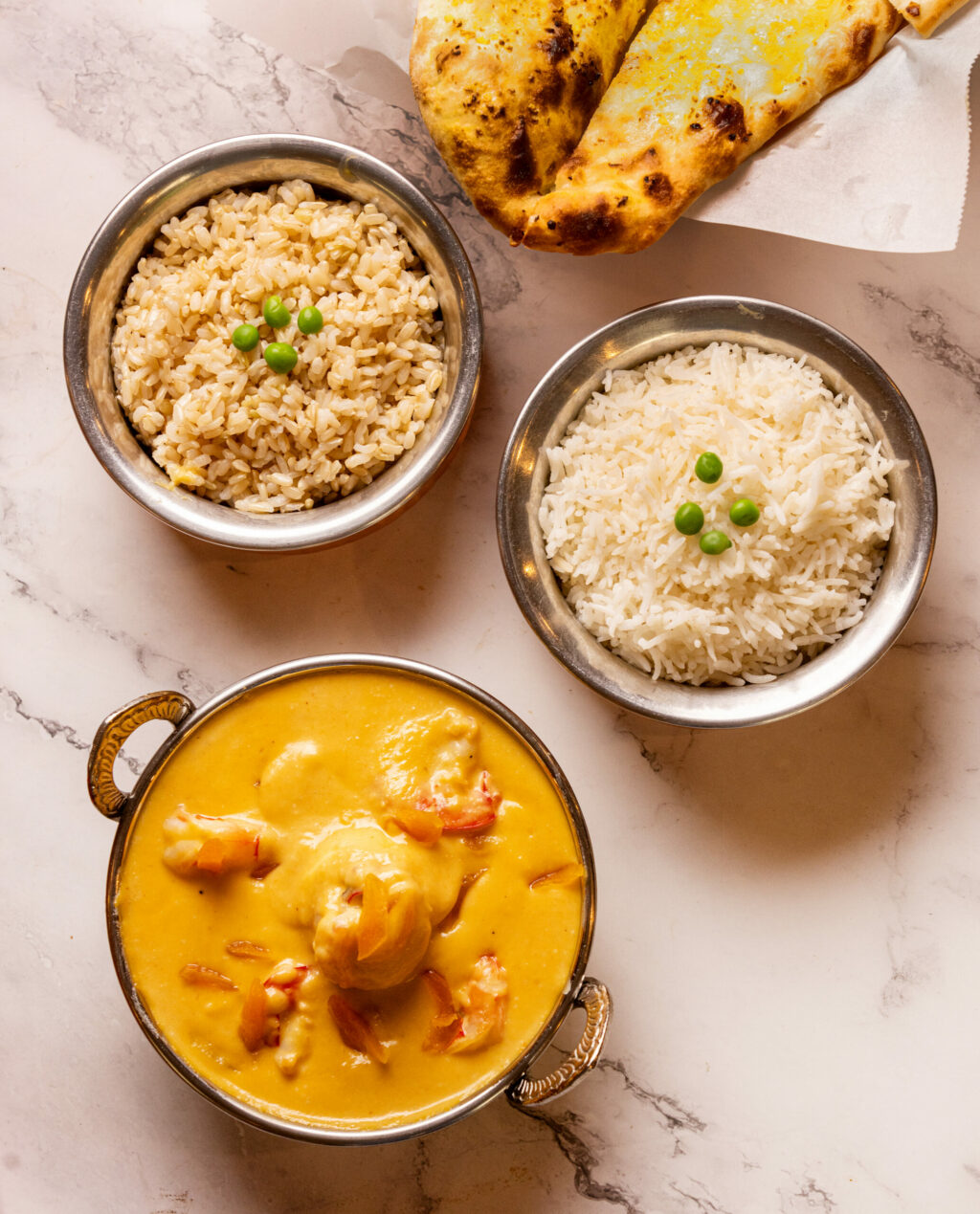 Apricot Shrimp with brown or white rice and naan on the side from Everest Restaurant Wednesday, July 24, 2024 in Cotati. (Photo by John Burgess/The Press Democrat)