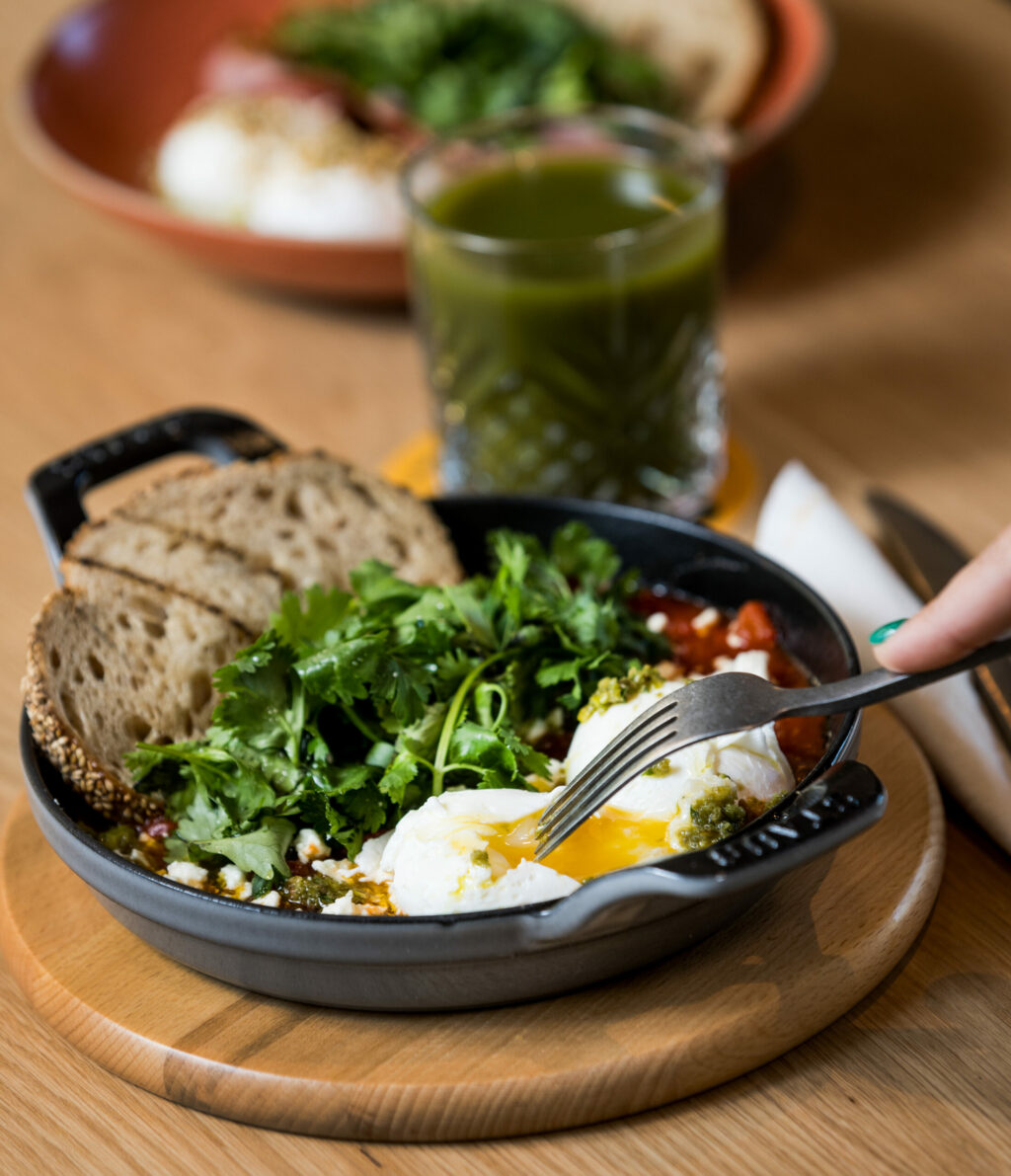 Healdsburg shakshuka with poached eggs, tomato shakshuka, eggplant, pistachio & green olive tapenade, fresh herbs and Goguette sourdough with a Big Sur juice from the Acorn Cafe Thursday, October 3, 2024 in Healdsburg. (John Burgess / The Press Democrat)