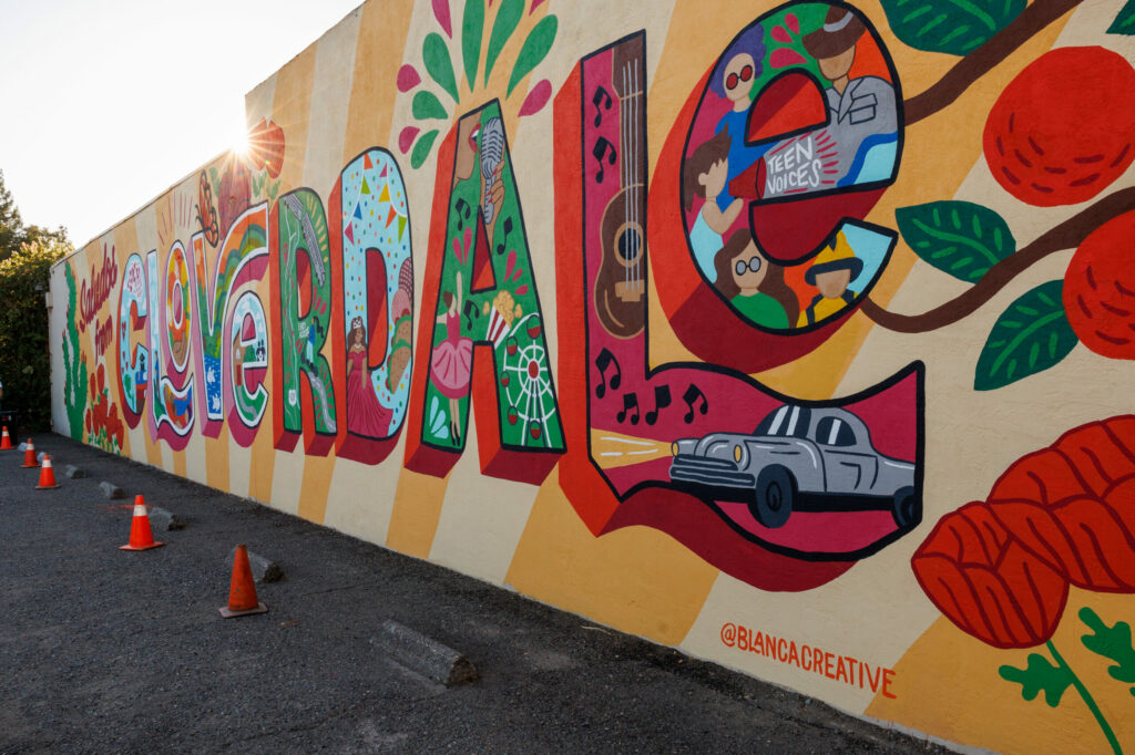 Blanca Molina’s mural stands on the corner of N. Cloverdale Boulevard and W. Second Street for its unveiling in Cloverdale on Sept. 20, 2024. (Abraham Fuentes/For The Press Democrat)