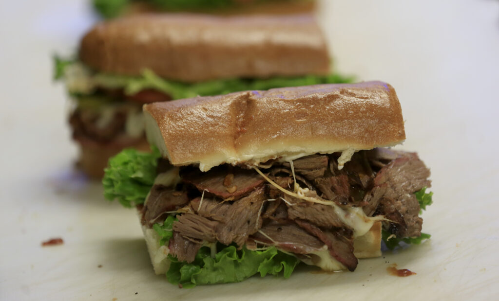 Samer 'Sam' Houraniaand put together tri-tip sandwiches smothered in caramelized onions and mozzarella cheese at Sam's Mediterranean Deli and Cafe, Thursday, April 15, 2021 in Rohnert Park. (Kent Porter / The Press Democrat) 2021