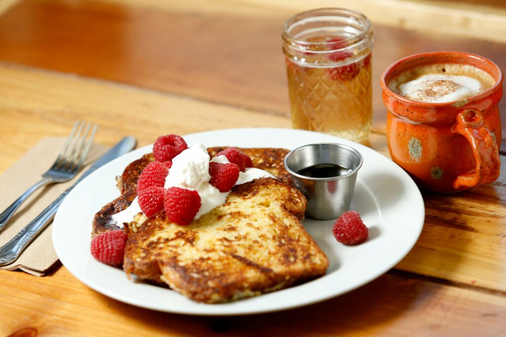 Cinnamon French toast made from Village Bakery brioche topped with butter, fresh whipped cream, organic raspberries and real maple syrup with sparkling wine and a cappuccino at Estero Cafe in Valley Ford, California on Wednesday, January 27, 2016. (Alvin Jornada / The Press Democrat)