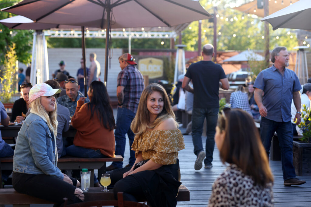 Friends Aine Fitzgerald, left, and Rachael Brackett enjoy a drink together at The Block Petaluma food park in Petaluma, Calif., on Saturday, May 14, 2022. (Beth Schlanker/The Press Democrat)